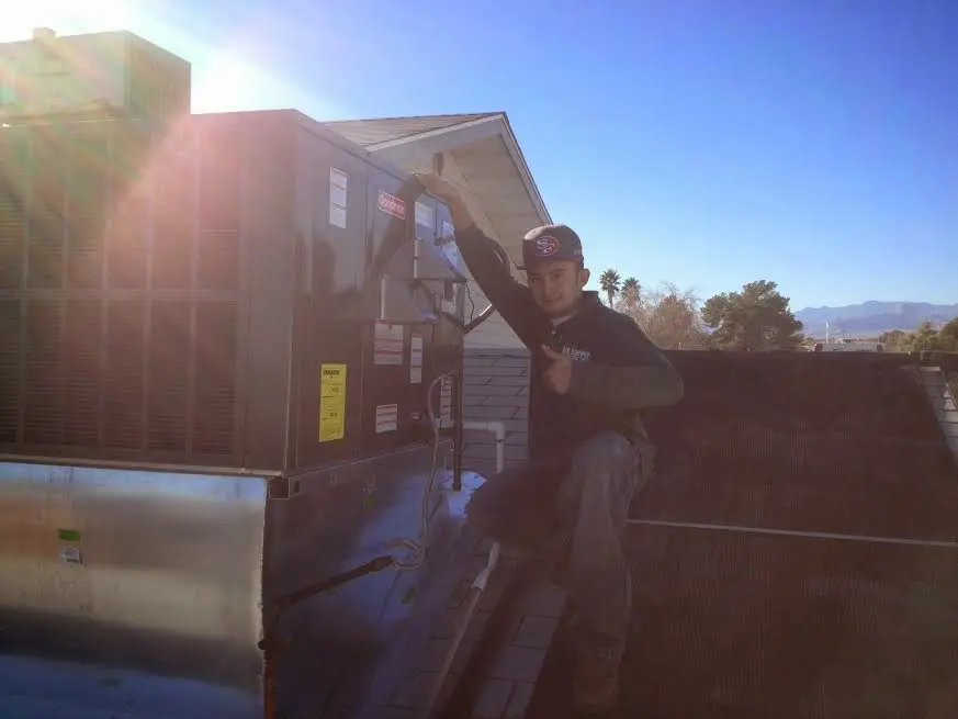 HVAC technician performing Air Duct Cleaning on a rooftop unit in Elko